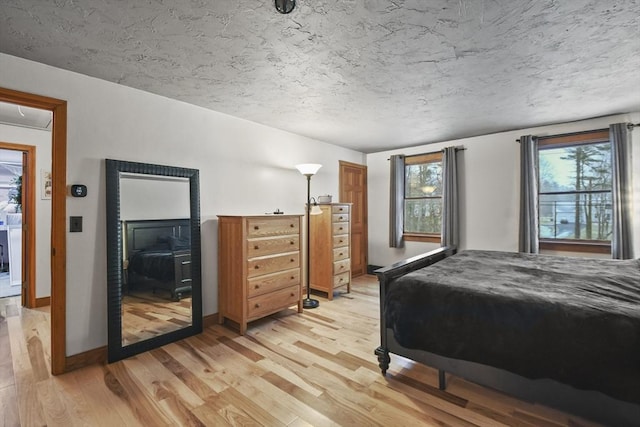 bedroom with multiple windows and light hardwood / wood-style flooring