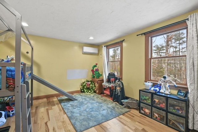 exercise area featuring hardwood / wood-style flooring and a wall mounted AC