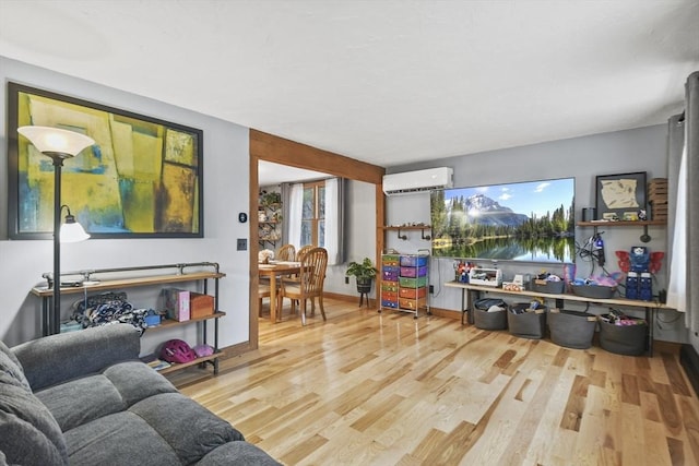 living room with hardwood / wood-style floors and a wall unit AC