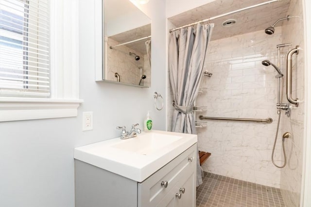 bathroom with vanity and tiled shower