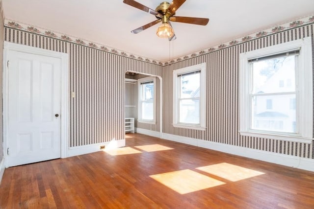 empty room with wallpapered walls and baseboards