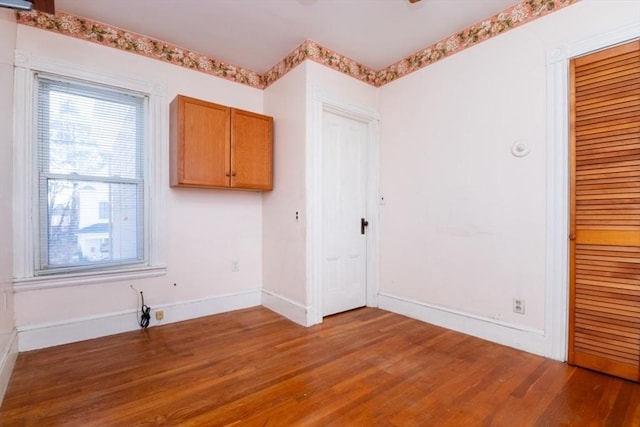 unfurnished room featuring baseboards and wood finished floors