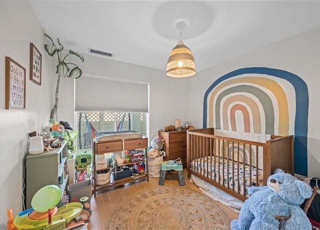 bedroom featuring wood finished floors and visible vents