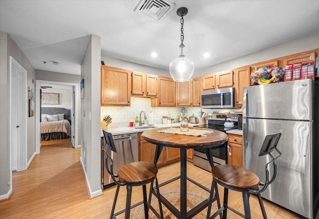 kitchen with visible vents, a sink, light countertops, appliances with stainless steel finishes, and backsplash