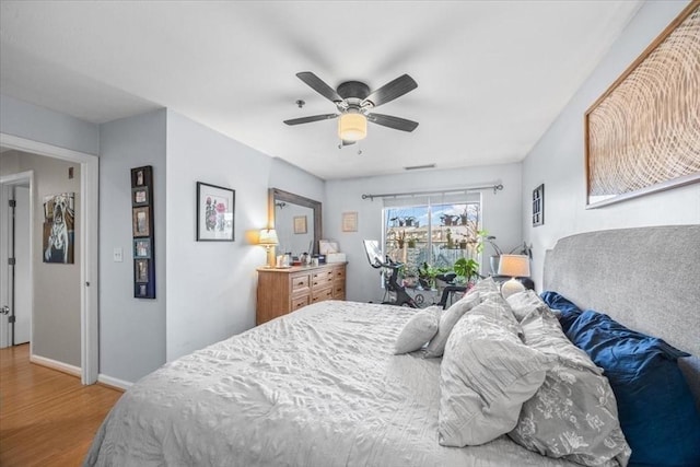 bedroom with ceiling fan, baseboards, and wood finished floors