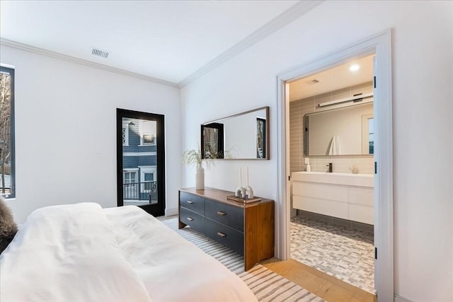 bedroom with ensuite bathroom, crown molding, and light hardwood / wood-style flooring