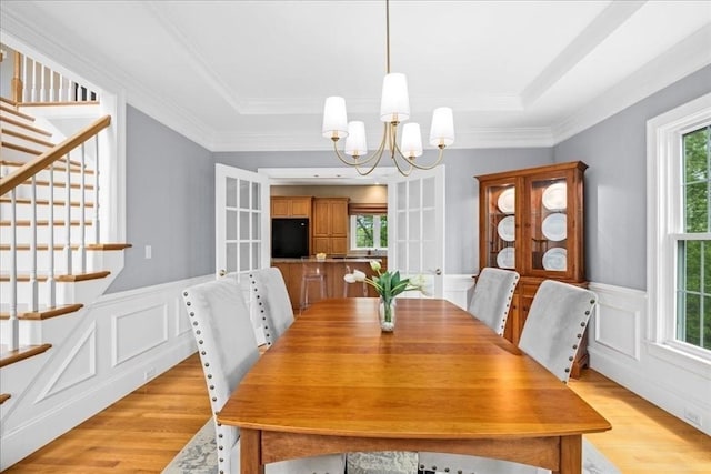 17 Fiddleneck Ln, Southborough, MA 01772 - dining room with light wood-style flooring, stairs, a chandelier, wainscoting, and crown molding