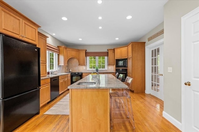 17 Fiddleneck Ln, Southborough, MA 01772 - kitchen featuring black appliances, a sink, light stone counters, an island with sink, and a kitchen bar