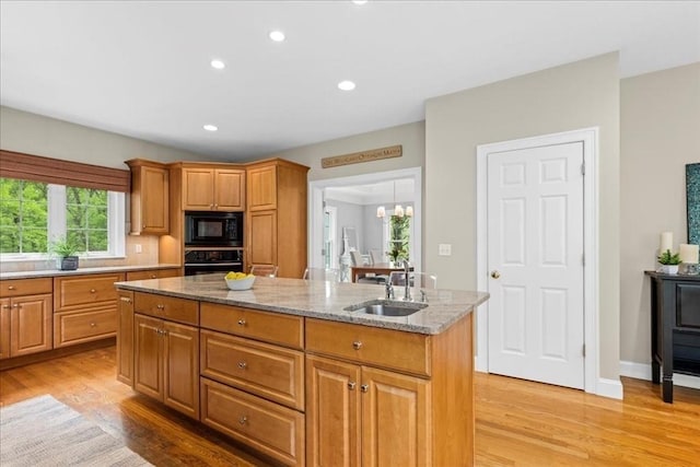 17 Fiddleneck Ln, Southborough, MA 01772 - kitchen featuring black appliances, a sink, a kitchen island, light wood finished floors, and light stone countertops