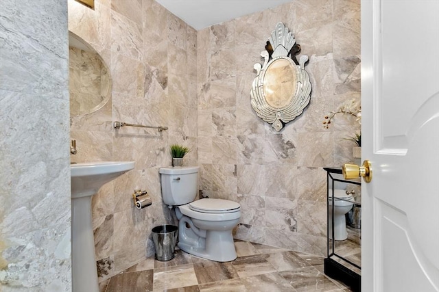 bathroom featuring toilet and tile walls