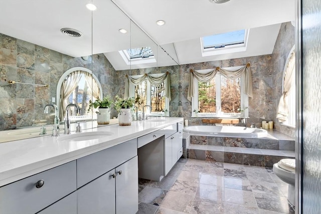 bathroom with vanity, toilet, and tile walls