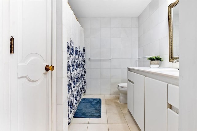 bathroom with a shower with curtain, vanity, tile walls, tile patterned flooring, and toilet