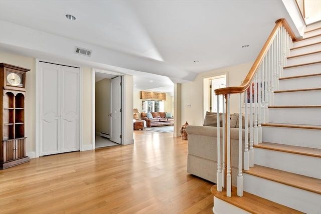 interior space with vaulted ceiling, light hardwood / wood-style flooring, and baseboard heating