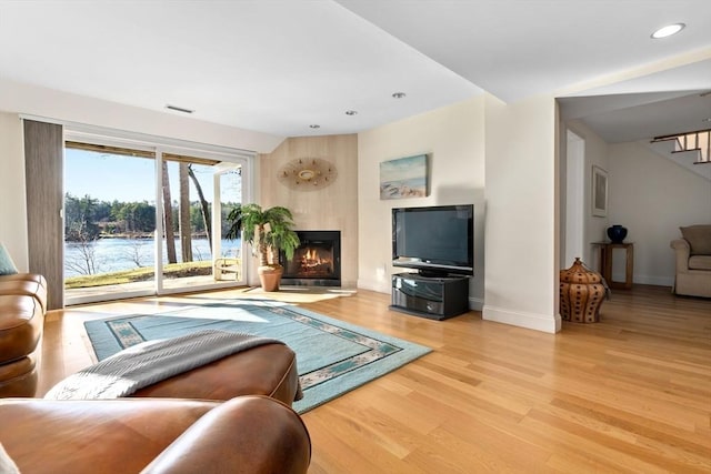 living room with a water view and light hardwood / wood-style flooring