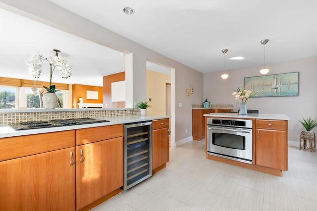 kitchen featuring decorative backsplash, hanging light fixtures, beverage cooler, and stainless steel appliances