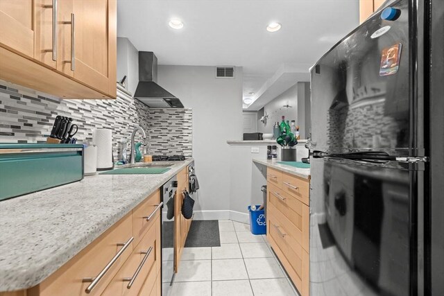 314 W 4th Unit 1, Boston, MA 02127 - kitchen with wall chimney exhaust hood, light tile patterned floors, backsplash, freestanding refrigerator, and oven