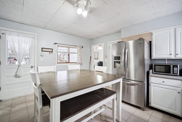 kitchen featuring white cabinetry, appliances with stainless steel finishes, light tile patterned floors, and ceiling fan