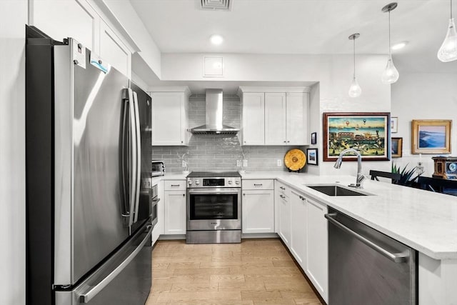 130 Broad Reach Unit 302, Weymouth, MA 02191 - kitchen with appliances with stainless steel finishes, wall chimney range hood, a peninsula, light wood-style floors, and white cabinets