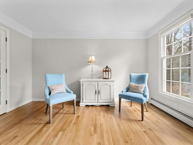 sitting room featuring plenty of natural light, light wood-type flooring, and a baseboard radiator