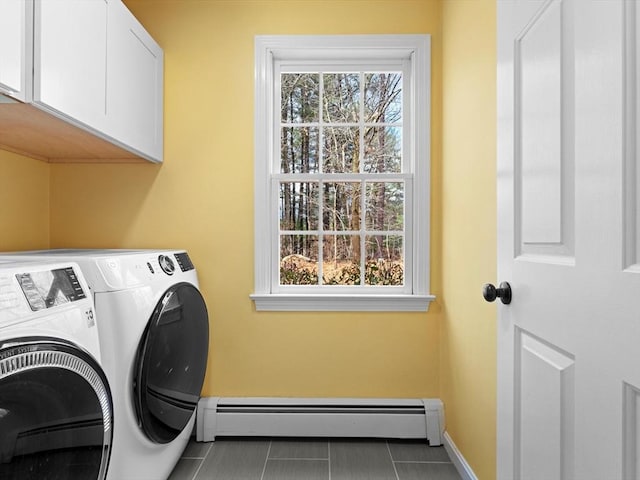 laundry room featuring a baseboard heating unit, cabinet space, a healthy amount of sunlight, and washing machine and clothes dryer