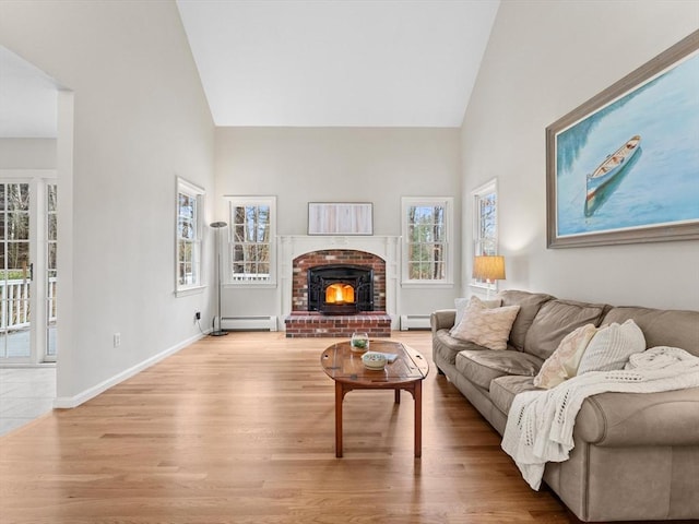 living room featuring a wealth of natural light, baseboard heating, and wood finished floors