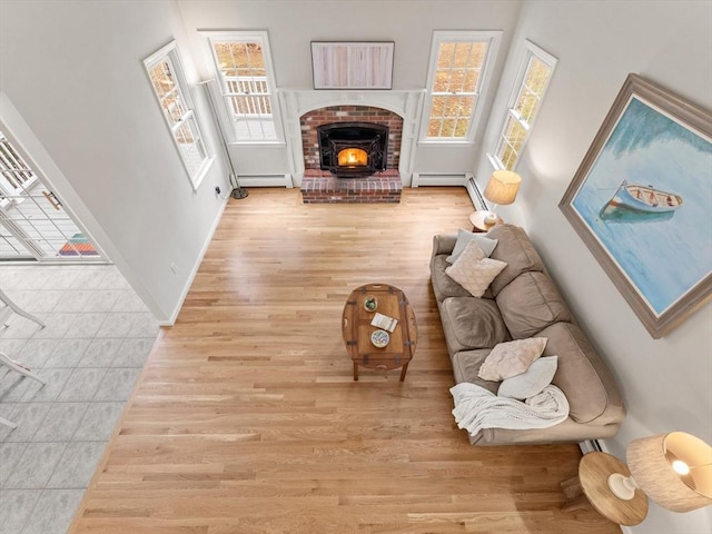 living room featuring baseboards, light wood-style floors, and a baseboard radiator