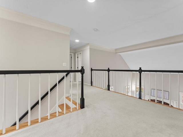 hallway featuring an upstairs landing, a decorative wall, recessed lighting, and crown molding