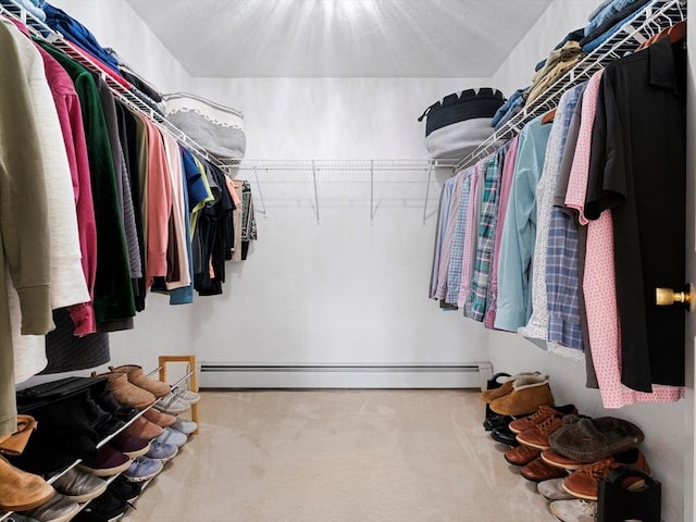 spacious closet with a baseboard heating unit and carpet floors