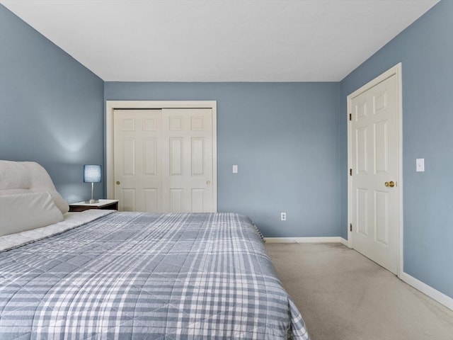 bedroom featuring a closet, baseboards, and carpet