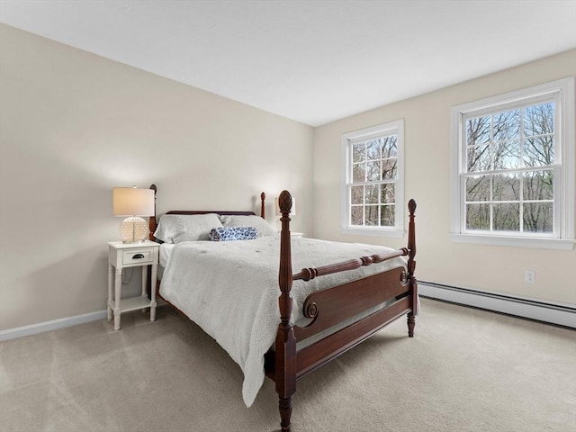 bedroom with a baseboard heating unit, baseboards, and carpet floors