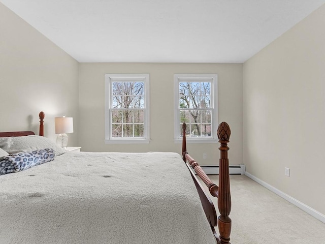 bedroom with a baseboard heating unit, baseboards, and light carpet