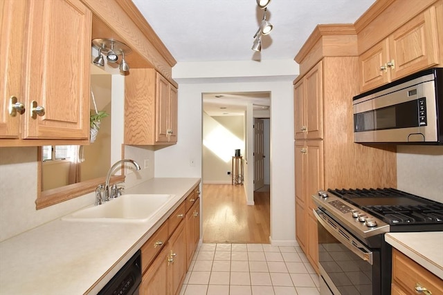 kitchen featuring a sink, light countertops, stainless steel microwave, light tile patterned floors, and range with gas cooktop