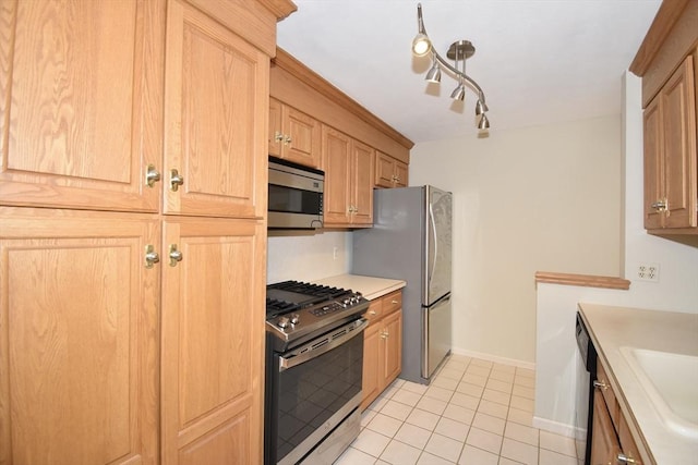 kitchen with a sink, light brown cabinets, light countertops, stainless steel appliances, and light tile patterned floors