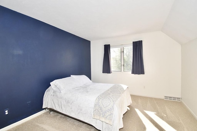 carpeted bedroom featuring baseboards, lofted ceiling, and visible vents
