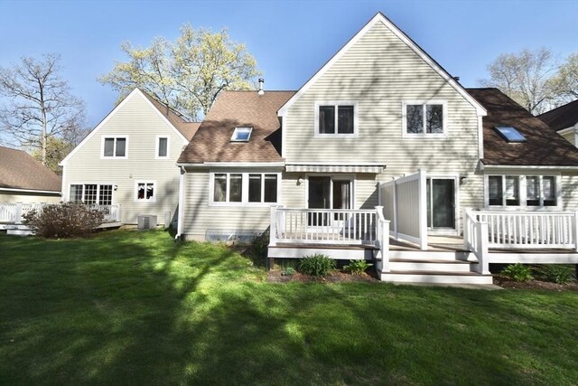 rear view of house featuring a lawn, roof with shingles, a wooden deck, and cooling unit