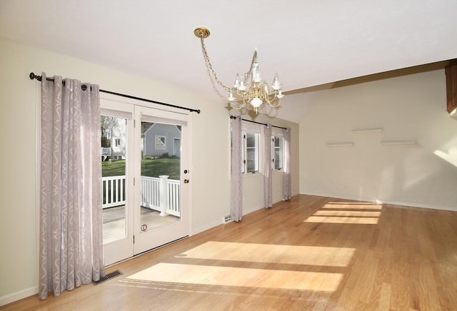interior space with light wood-style floors, baseboards, visible vents, and a notable chandelier