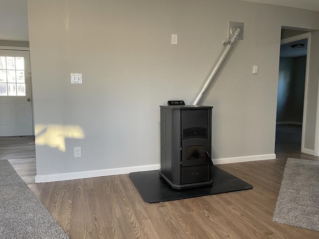 interior details with hardwood / wood-style flooring and a wood stove