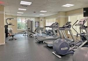 gym with a drop ceiling and baseboards