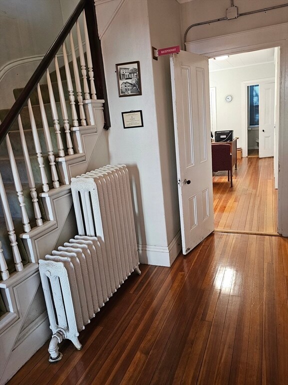 hall with radiator heating unit and dark hardwood / wood-style floors