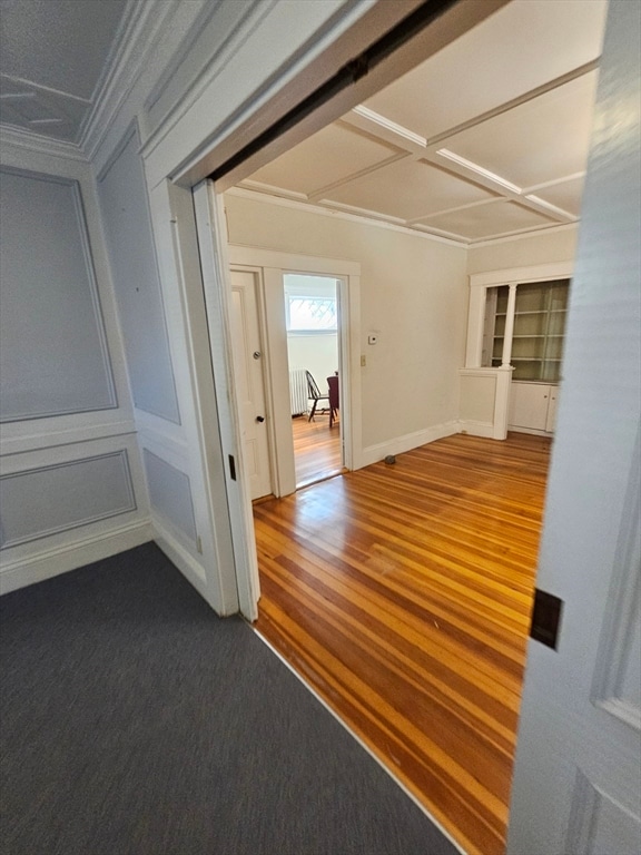 corridor featuring ornamental molding and hardwood / wood-style flooring