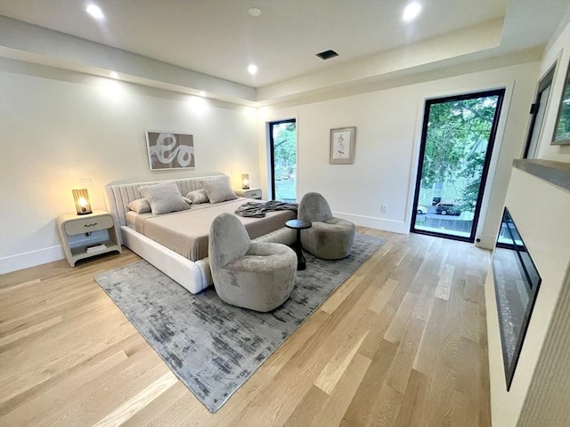 156-158 Langley Rd Unit 1, Newton, MA 02459 - bedroom with a tray ceiling, light wood-style flooring, access to exterior, and recessed lighting