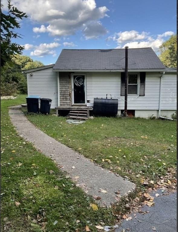 view of front of home featuring entry steps, heating fuel, and a front yard