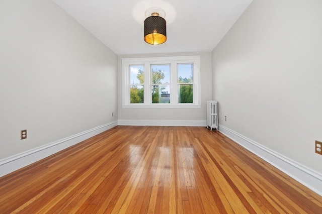 empty room with light wood-type flooring and radiator