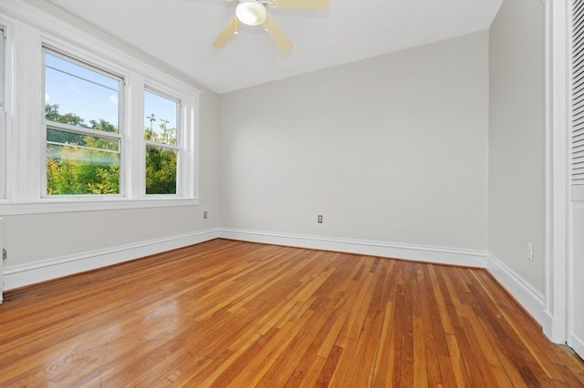 empty room with hardwood / wood-style floors and ceiling fan