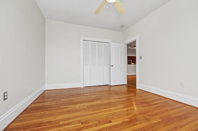 unfurnished bedroom featuring ceiling fan, light wood-type flooring, and a closet