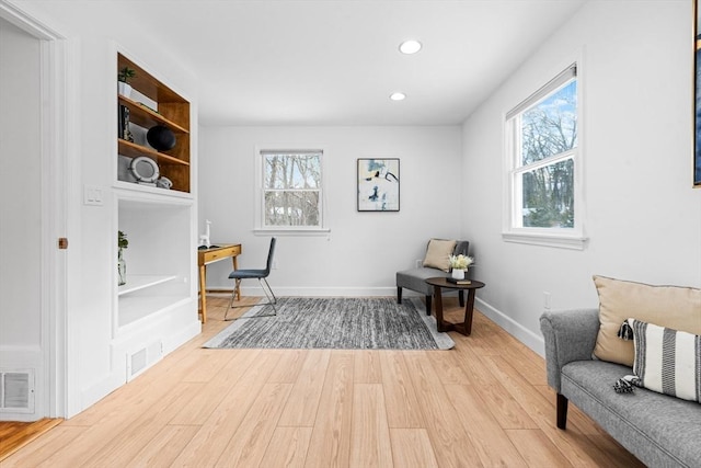 sitting room with light wood-style floors, recessed lighting, visible vents, and baseboards