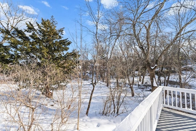 snowy yard featuring a wooden deck