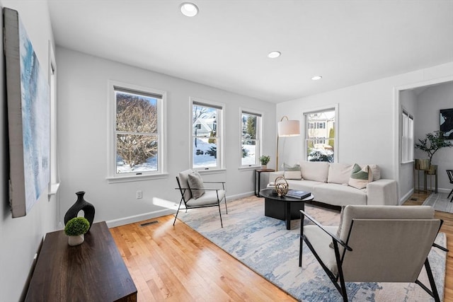 living area featuring baseboards, wood finished floors, visible vents, and recessed lighting