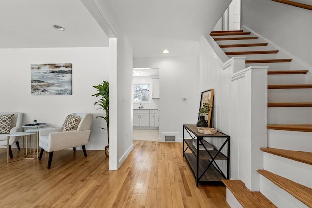 foyer entrance featuring recessed lighting, visible vents, stairway, light wood-type flooring, and baseboards