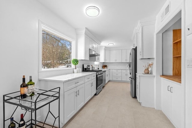 kitchen with visible vents, white cabinets, stainless steel appliances, light countertops, and under cabinet range hood